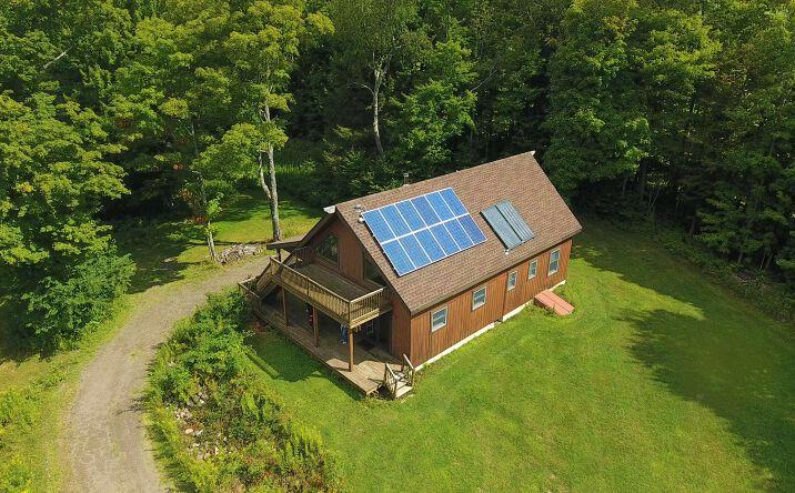 Off-grid cabin with solar panels on rural land