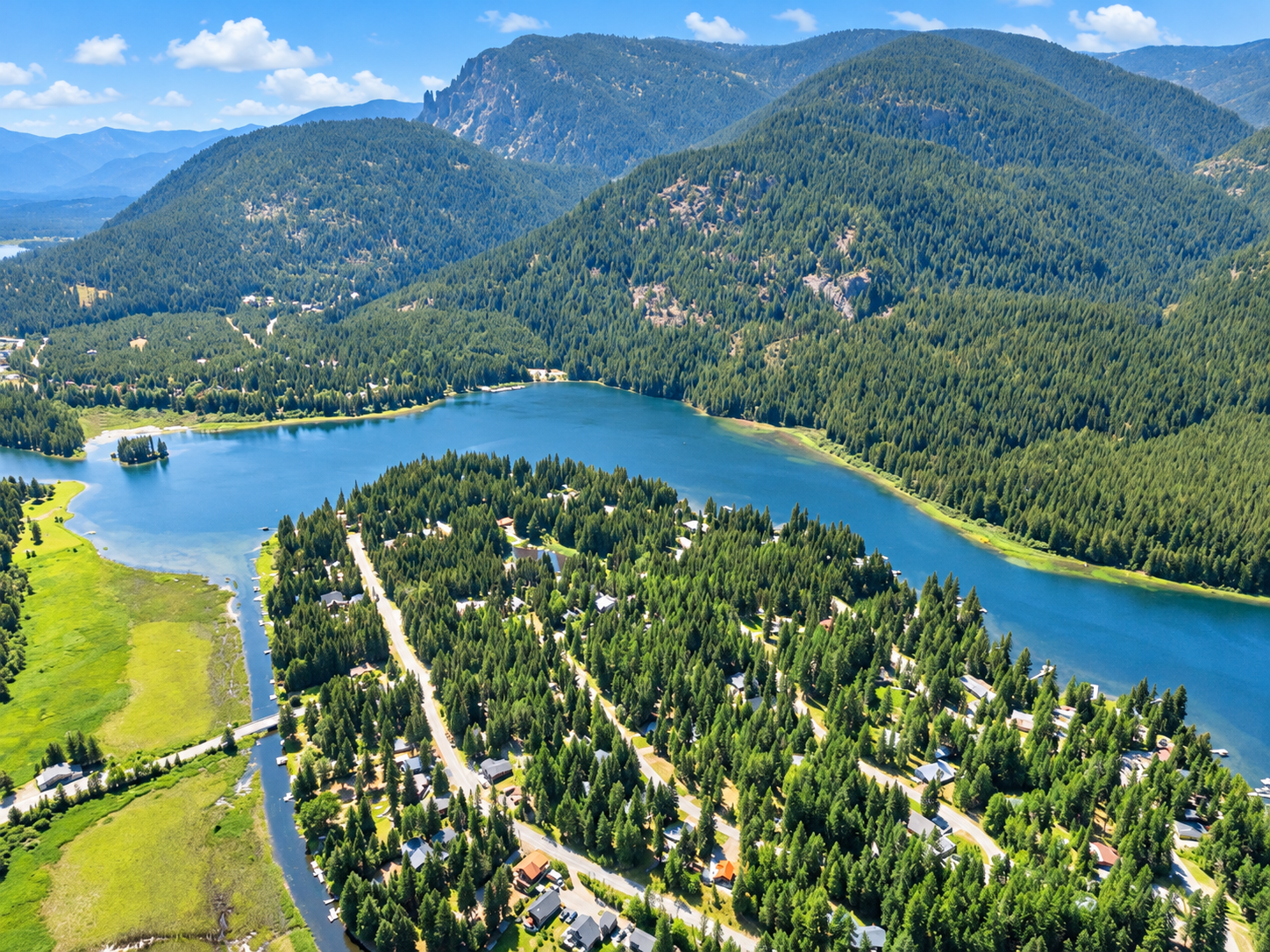 Drone view of Bull Lake shoreline, evergreen mountain slopes and the Angel Island neighborhood