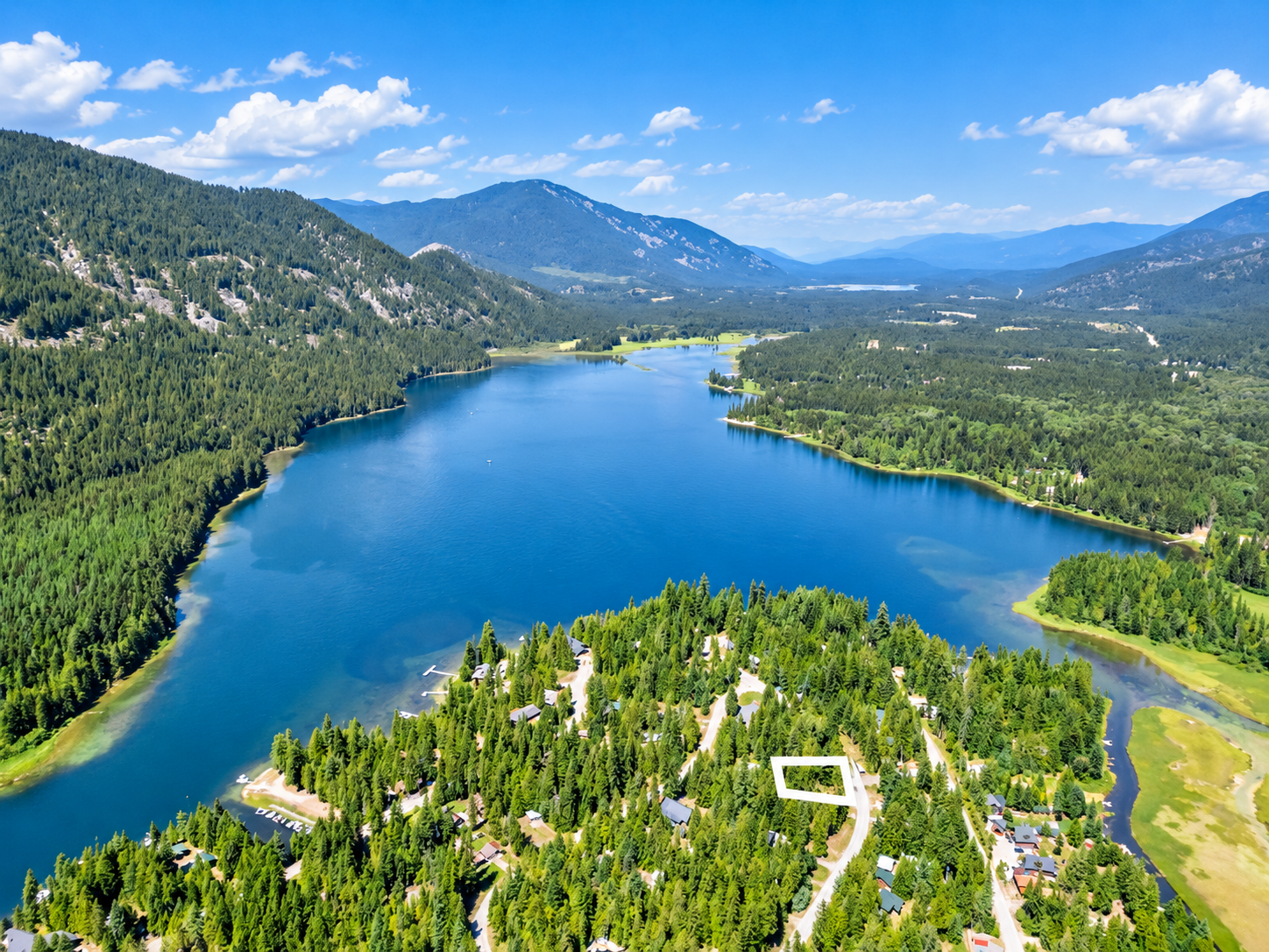 Aerial photo of Bull Lake with the 0.26-acre Angel Island lot for sale outlined among trees and homes