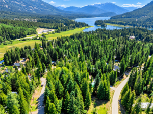 Aerial of evergreen-lined Angel Island roads with Bull Lake and mountain ridges in the distance