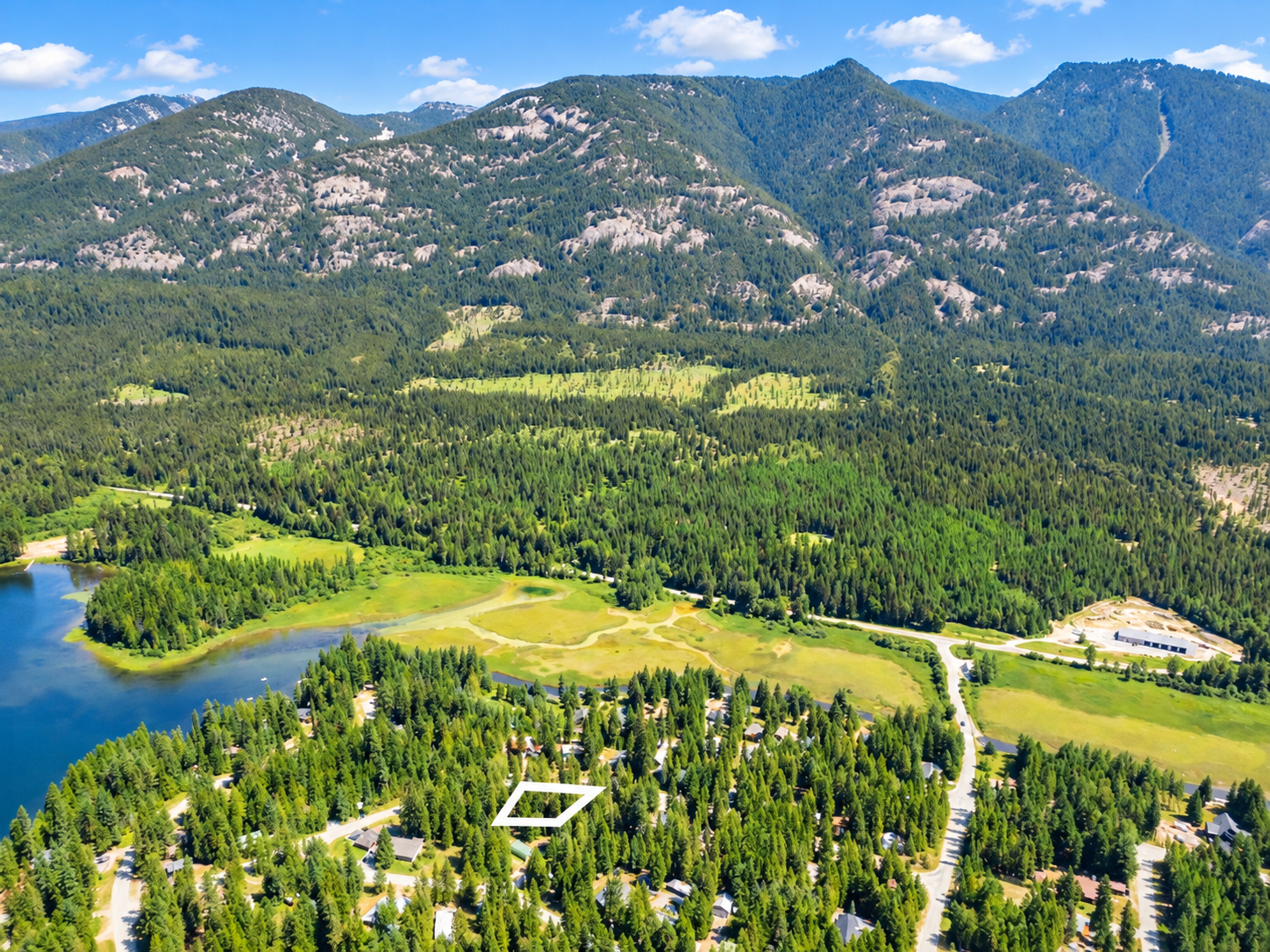 Outlined 0.26-acre wooded lot with Bull Lake shoreline and mountains behind it near Troy, MT