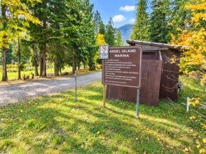 Angel Island Marina sign beside a wooded road near Bull Lake in Lincoln County, Montana