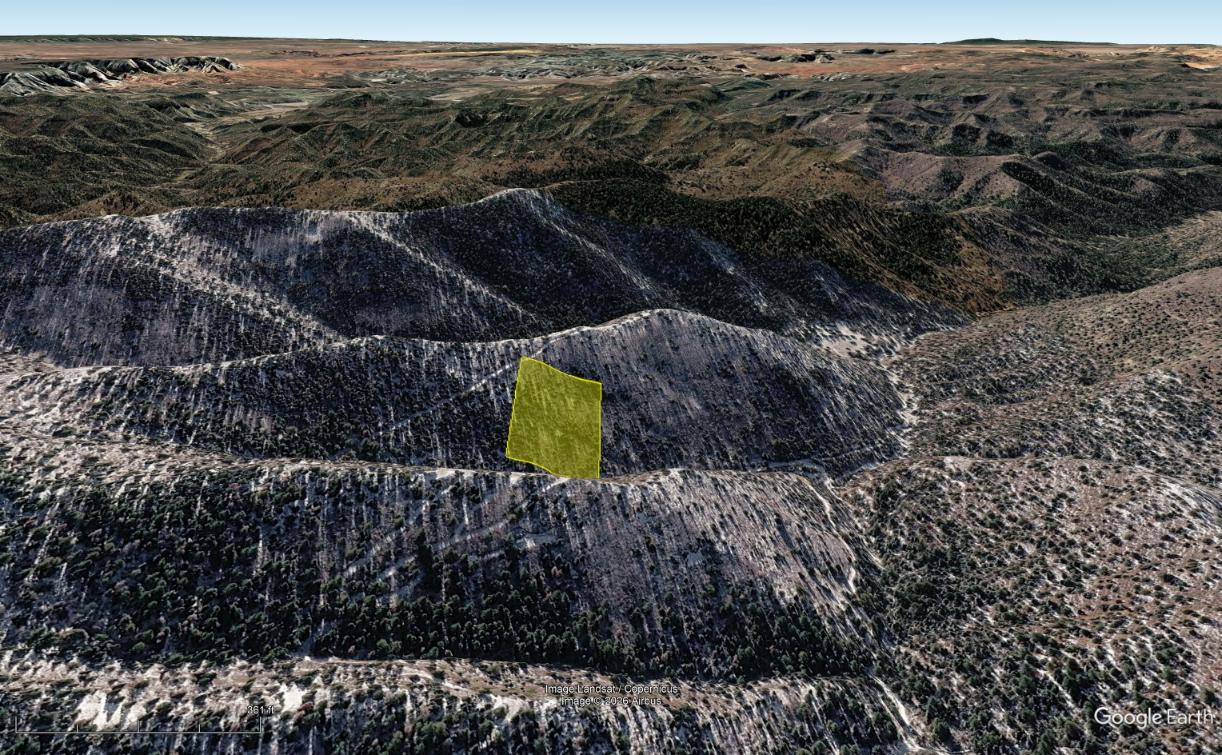 Google Earth perspective of the highlighted parcel on a sloping hillside among surrounding ridges